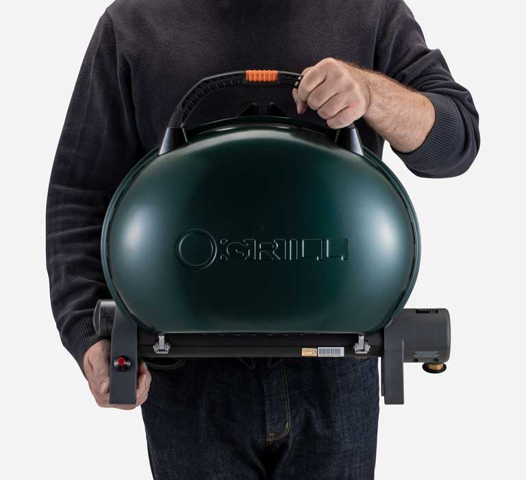 A person is holding O-Grill 500M Portable Gas Grill